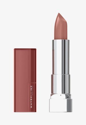 Rossetto Maybelline in una tonalità nude rosa opaco. La matita è contenuta in un astuccio metallico argento accanto a un cappuccio rettangolare bordeaux lucido.