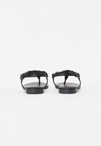 Sorte svarte sandaler med flettet stroppdesign, justerbar spenne og minimalistisk såle.