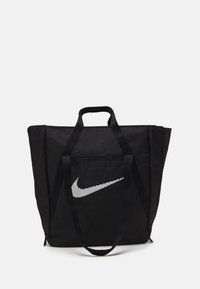 Zwarte Nike tas met dubbele handgrepen en witte gestileerde swoosh-logo op de voorkant, tegen een witte achtergrond.