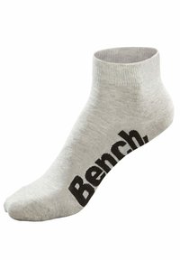 Harmaat nilkkasukat, jotka on tehty pehmeästä kankaasta, ja joissa on röyhelötekstuuri sekä musta "Bench"-logo painettuna sivulle.