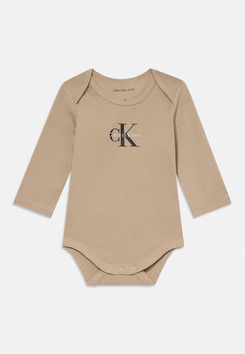 Bežinis ilgomis rankovėmis kūdikių bodysuit’as su juodu ir baltu Calvin Klein Jeans logotipu, atspausdintu krūtinėje, su spaudimo mygtukais tarp kojų.