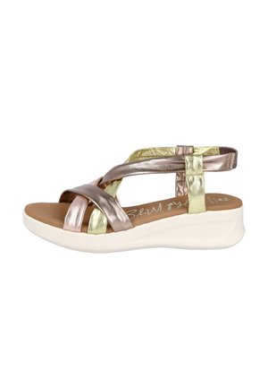 Sandalias de tiras metálico bronce y oro con plantilla acolchada marrón, suela blanca de plataforma y textura suave y lisa.