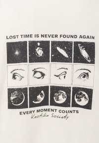 Camisa blanca con un gráfico negro que presenta nueve paneles de imágenes celestiales y ojos, con el texto "EL TIEMPO PERDIDO NUNCA SE ENCUENTRA DE NUEVO" y "CADA MOMENTO CUENTA".