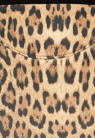 Tkanina z vzorom leoparda, ki ima zlatomorjeno ozadje z temnimi madeži, gladko teksturo in ukrivljen rob na vrhu.