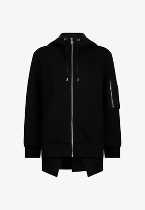 Sweat à capuche noir zippé avec une poche avant, des cordons de serrage et une poche latérale avec fermeture éclair. Matière douce et coupe décontractée avec une fente au bas.