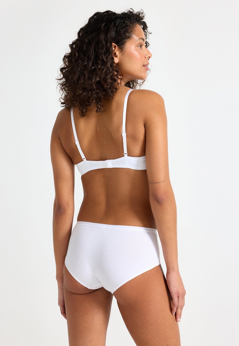 Ensemble de soutien-gorge et culotte blanc en coton doux. Bretelles réglables et fermeture à crochets sur le soutien-gorge. La culotte a un design simple et sans coutures.