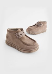 Bottes chelsea en daim marron avec des semelles en caoutchouc texturé, featuring des accents de lacets bicolores et un design à bout rond. Convient aux enfants.