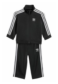 Black Adidas tracksuit with white stripes. Zip-up jacket features a standing collar; pants have an elastic waistband and side stripes.