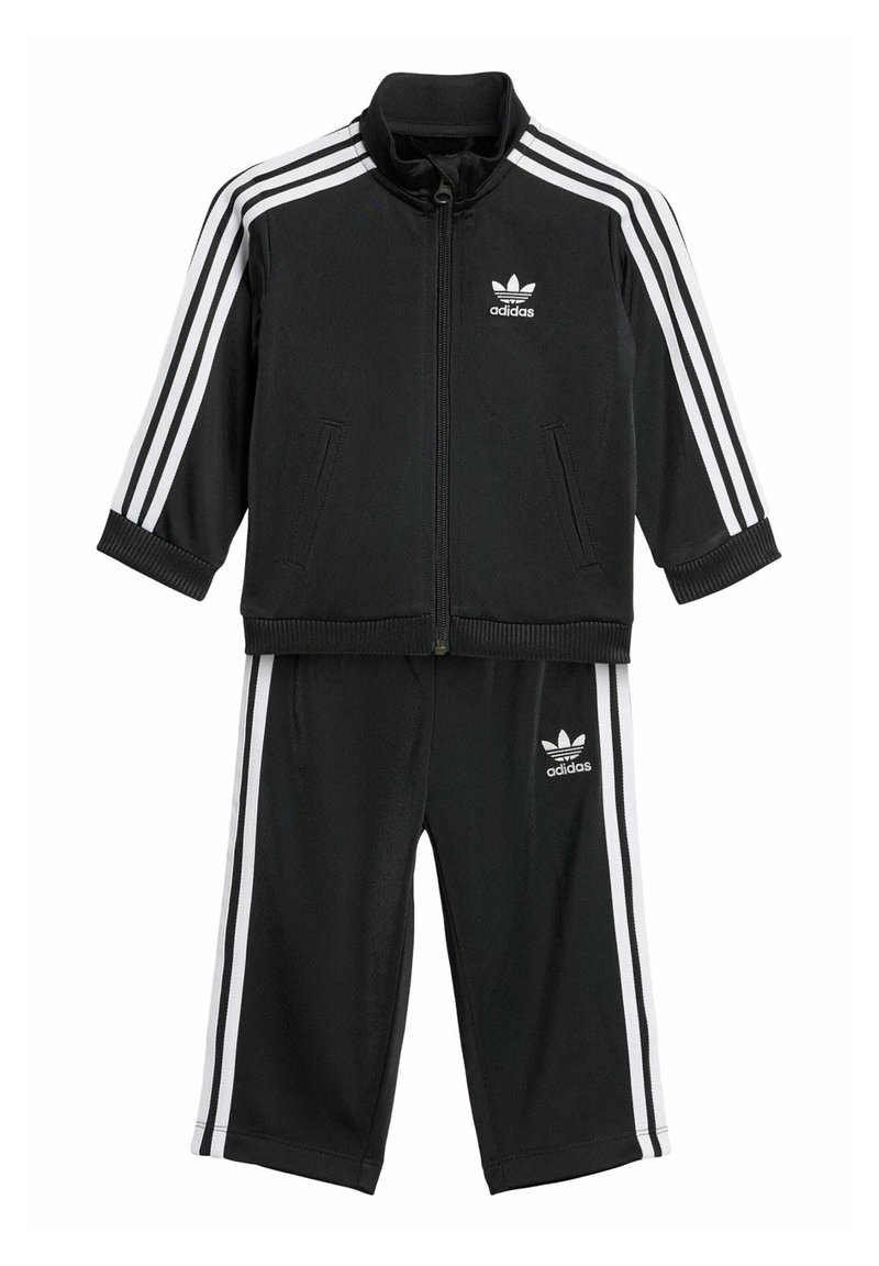 Black Adidas tracksuit with white stripes. Zip-up jacket features a standing collar; pants have an elastic waistband and side stripes.