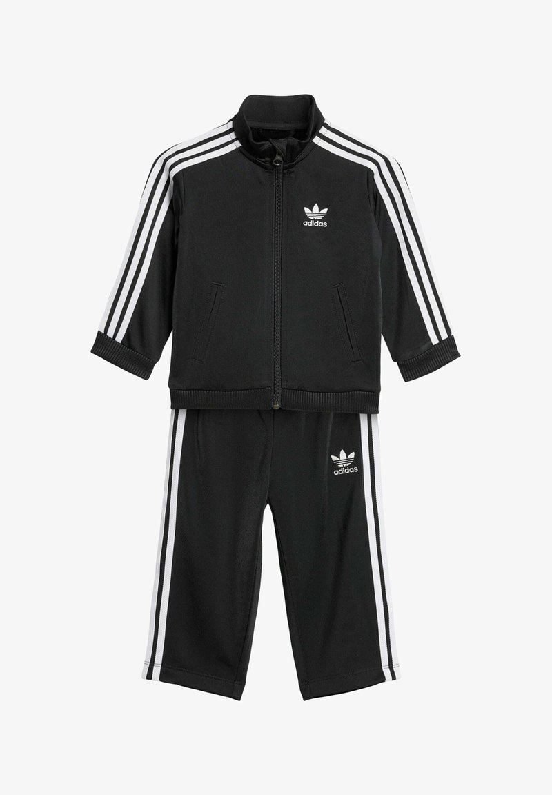 Black Adidas tracksuit with white stripes. Zip-up jacket features a standing collar; pants have an elastic waistband and side stripes.