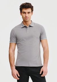 Szary polo wykonany z bawełny. Posiada zapięcie na trzy guziki, kontrastowy kołnierzyk oraz krótkie rękawy z paskowanymi akcentami.