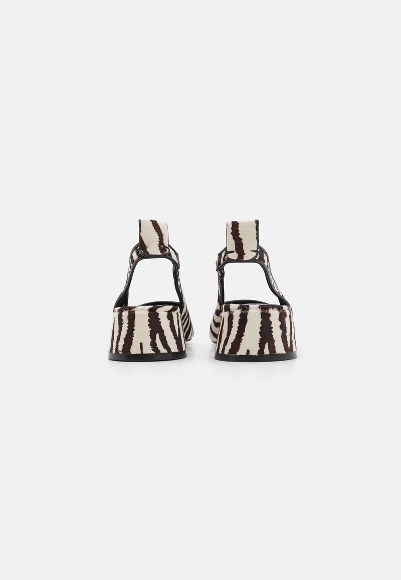 Sandali con zeppa dal motivo a strisce zebra in crema e marrone scuro, con design aperto e suola nera.