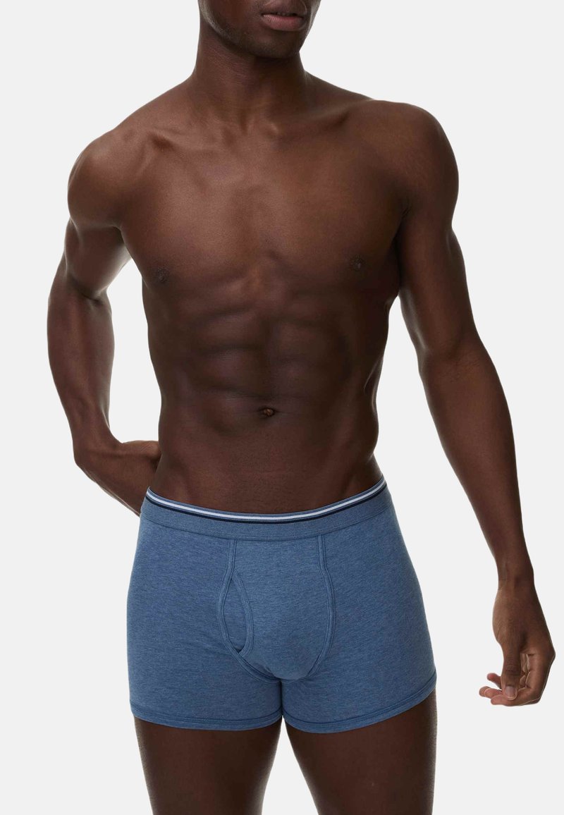 Blå bomullsboxershorts med en åtsittande passform, med en kontrasterande midja med en subtil rand. Slät textur och atletisk design.