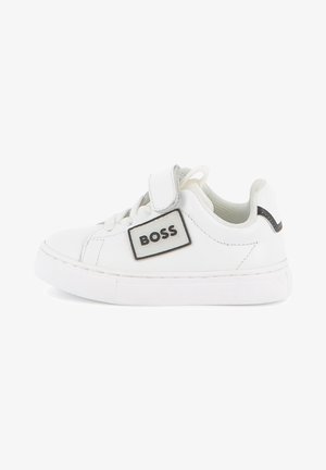 Baskets basses blanches avec bride Velcro, lacets et logo noir "BOSS" sur le côté, avec un col matelassé et une semelle épaisse.