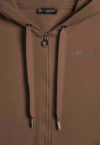 Felpa con zip marrone realizzata in morbido tessuto, con logo argentato decorato con strass e accessori in argento sulla zip e sui lacci.