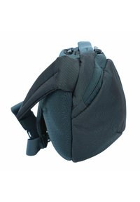 Sac en tissu gris avec une finition texturée, présentant une forme arrondie, des bretelles réglables et un système de fermeture à cordon en haut.
