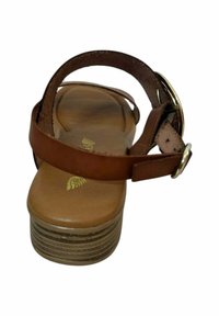 Sandalia de cuero marrón con correa ajustable, tacón bajo en bloque y plantilla acolchada en tono beige. Acentos de hardware dorado y suela texturizada.