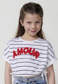 Top corto de rayas blancas con texto bordado en rojo "AMOUR" y detalle en plateado "Kawaii Girl", con dobladillo ajustable y mangas cortas.