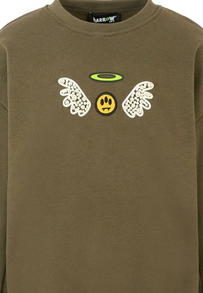 Felpa verde oliva con colletto rotondo, caratterizzata da un sorriso giallo con dettagli neri, ali bianche da angelo e un alone verde.