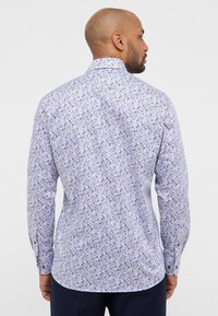 Lange mouw shirt van lichtblauwe stof met een bloemenpatroon, met een standaard kraag en knopenmanchetten. Zachte textuur en gebogen zoom.