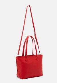 Red synthetic tote bag with dual top handles and a detachable shoulder strap. Smooth texture, rectangular shape, minimal hardware.