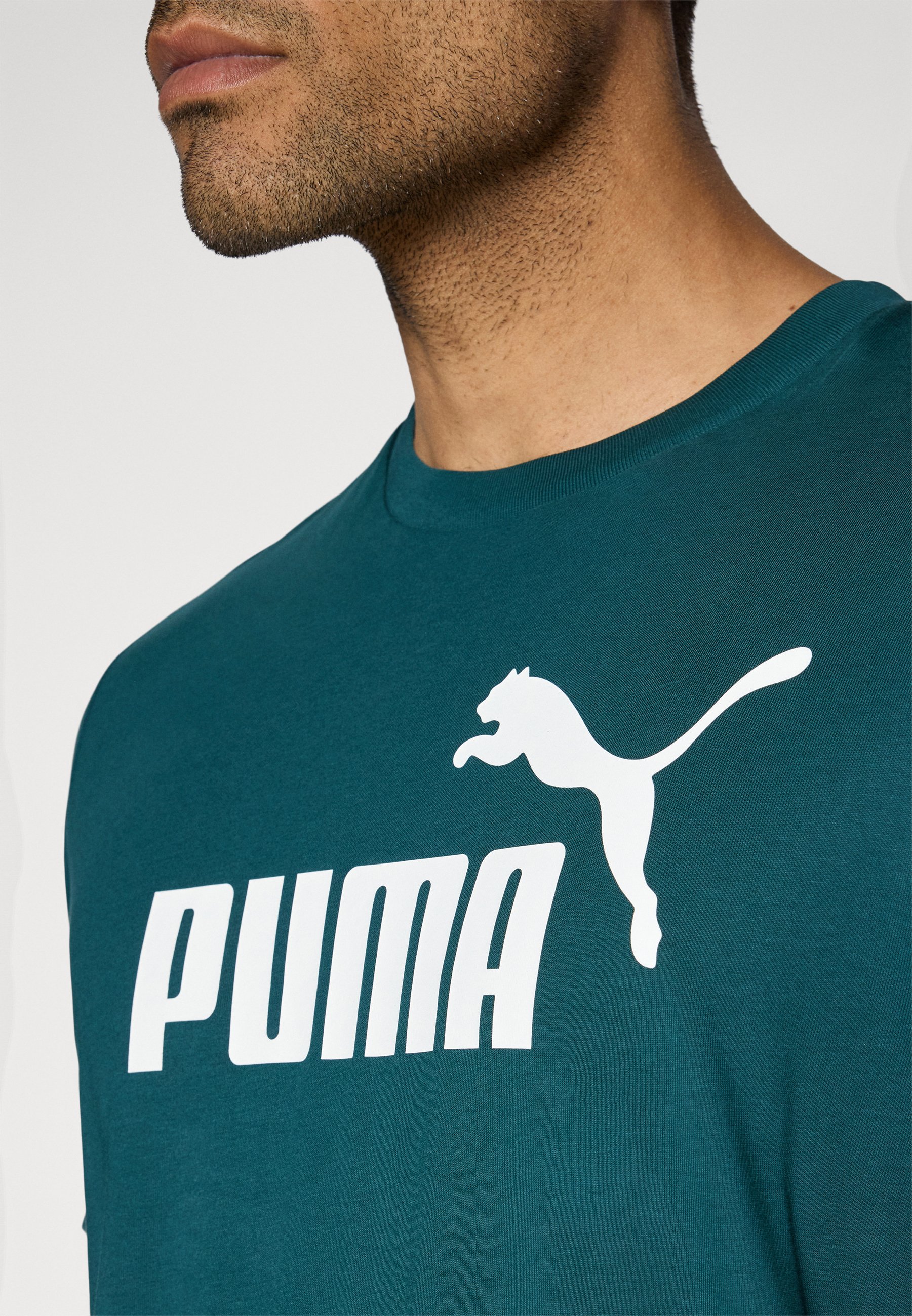 Puma LOGO TEE - Camiseta estampada - green terrain/negro jaspeado -  Zalando.es