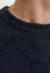 Granatowy wełniany sweter z prążkowanym dekoltem, ukazujący miękką teksturę i zbliżenie na puszystość tkaniny.