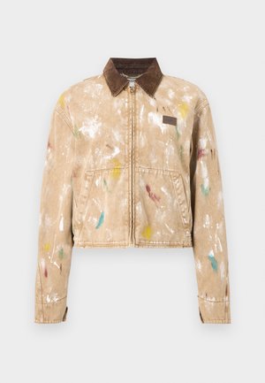 Giacca beige con chiusura a zip, colletto in velluto a coste marrone, schizzi di vernice multicolori, tasche frontali e una piccola toppa in pelle sul petto.