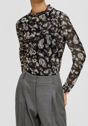 Top a maniche lunghe con un motivo floreale nero e grigio, caratterizzato da un collo alto. Abbinato a pantaloni grigi a vita alta, che presentano delle pinces.