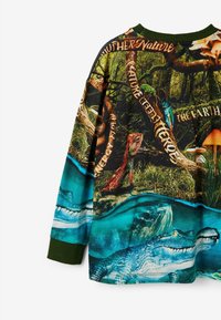 Koszulka z długim rękawem z intensywnym nadrukiem dzikiej przyrody przedstawiającym krokodyle, jaszczurki i drzewa. Zielony prążkowany kołnierzyk i teksturowana tkanina.