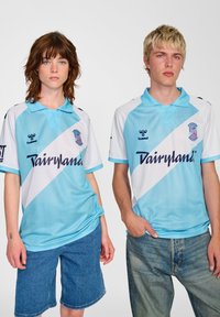 Ljusblå och vita lagtröjor med diagonalt randig design, som har logotyp och texten "Dairyland", tillverkade av andningsbart tyg.