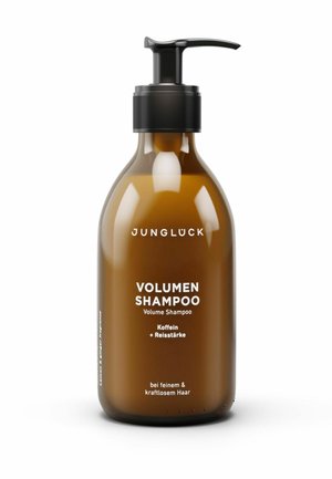 Bernsteinfarbene Pumpflasche mit der Aufschrift Junglück Volumen Shampoo mit Koffein und Reisstärke für feines, schwaches Haar vor weißem Hintergrund.