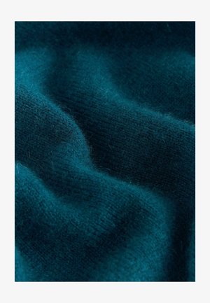Woolna tkanina w kolorze zielono-niebieskim z miękką teksturą i delikatnymi falami, ukazująca finezyjne wzory dzianinowe oraz lekką puszystość.