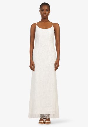 Langes weißes Kleid mit einem strukturierten Muster, Spaghettiträgern und einer geraden Silhouette, verziert mit filigraner珠arbeit und einem transparenten Saum.