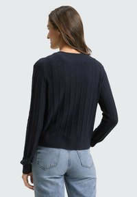 Marineblauer, gerippter Pullover mit langen Ärmeln und rundem Ausschnitt, ausgestattet mit einem strukturierten Strickmuster und einer verkürzten Passform.