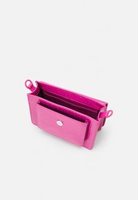 Borsa in pelle sintetica rosa effetto coccodrillo con due scomparti e chiusura a bottone. Presenta piccole asole per attacchi o tracolle.