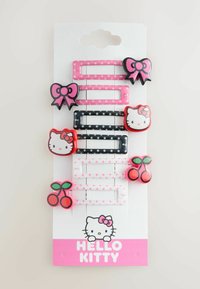 Färggranna hårspännen med design av rosa och svarta prickar, rosetter, Hello Kitty och körsbär, presenterade på ett märkt kort.