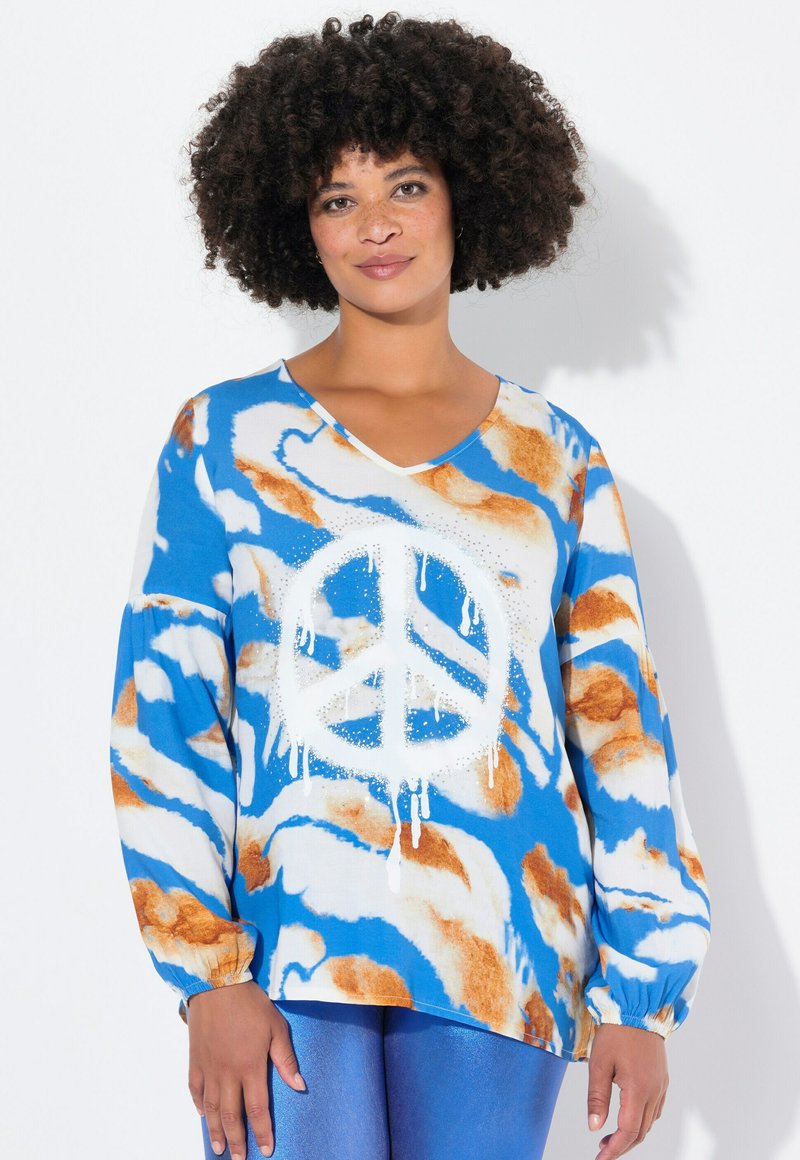 Top a maniche lunghe con scollatura a V blu, decorato con motivi astratti bianchi e arancioni. Presenta una grande grafica di un simbolo della pace bianco con effetto goccia.