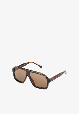 Oversized vierkante zonnebril met schildpadmotief, bruine getinte glazen en dikke monturen op een witte achtergrond.