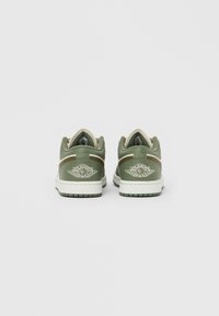 Groene leren sneakers met een witte middenzool. Ronde neus, gevoerde kraag en geborduurd vleugel-logo. Platte zolen met horizontale gripprofielen.