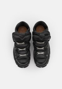 Black leather high-top sneakers with a rounded toe, prominent cushioned tongue, and silver hardware accents on the laces.
