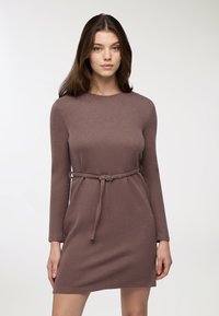 Abito in maglia di colore malva con maniche lunghe, caratterizzato da una vita con cinturino e un collo rotondo. Tessuto morbido e design semplice.