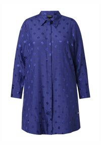 Camisa de manga larga con cuello, hecha de un tejido azul oscuro y suave, decorada con lunares de color navy de diferentes tamaños, y cuenta con un cierre de botones.