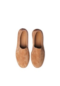 Chaussures slip-on en daim marron avec une texture douce, bout arrondi et inserts élastiques sur les côtés pour un enfilage facile. Détails de couture légers le long des bords.