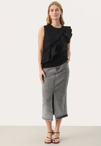 Black sleeveless top with ruffled detail along one shoulder, paired with a grey denim midi skirt featuring a front slit and black strappy sandals.