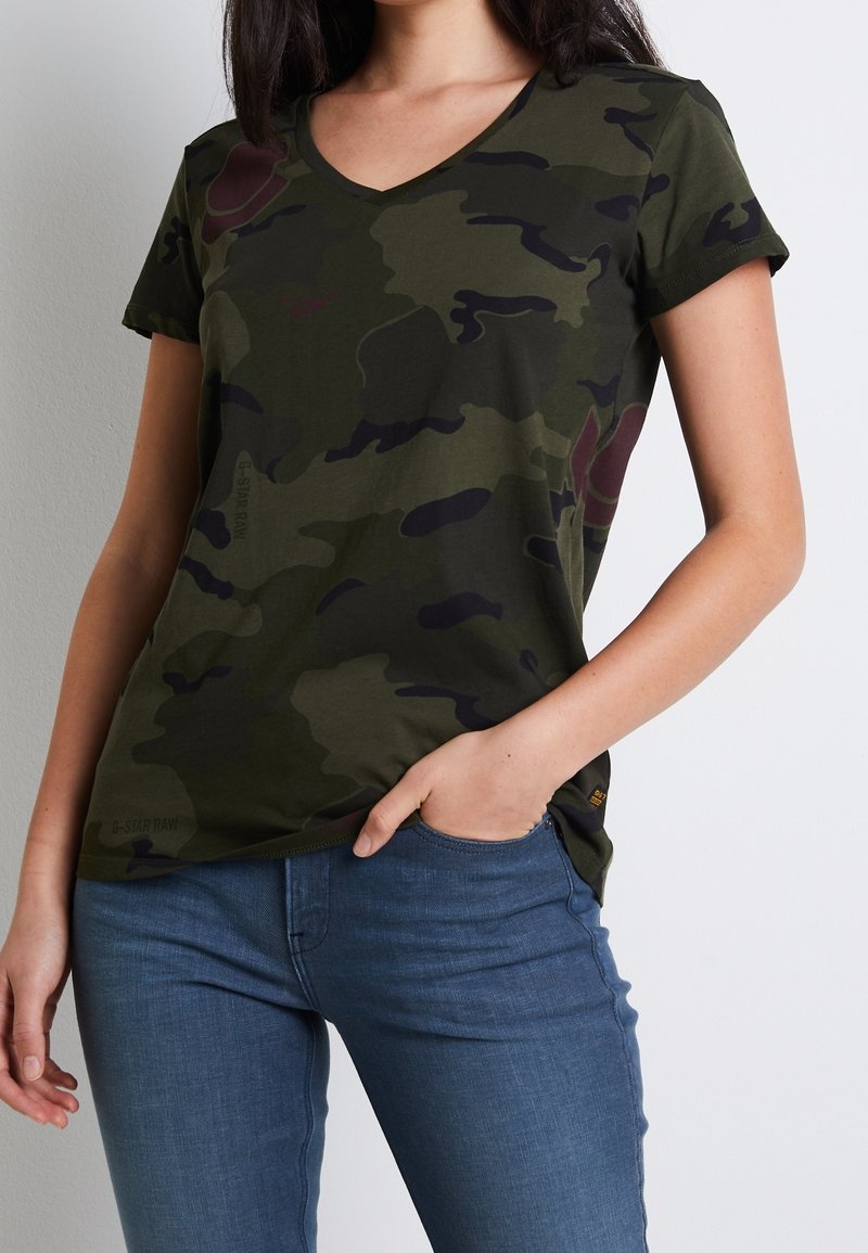 Olivgrön kamouflage t-shirt med korta ärmar och V-ringning, tillverkad av mjukt bomull. Har diskret logo vid nederkanten och en figurnära design.