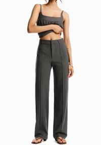 Gray high-waisted trousers with a straight-leg cut, featuring subtle front seams and a smooth texture. Paired with a gray cropped top.
