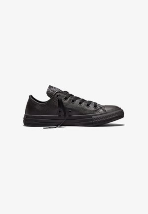 Zapatilla de cuero negra de perfil bajo con cordones negros, suela de goma y puntera, mostrada en perfil lateral mirando hacia la derecha.