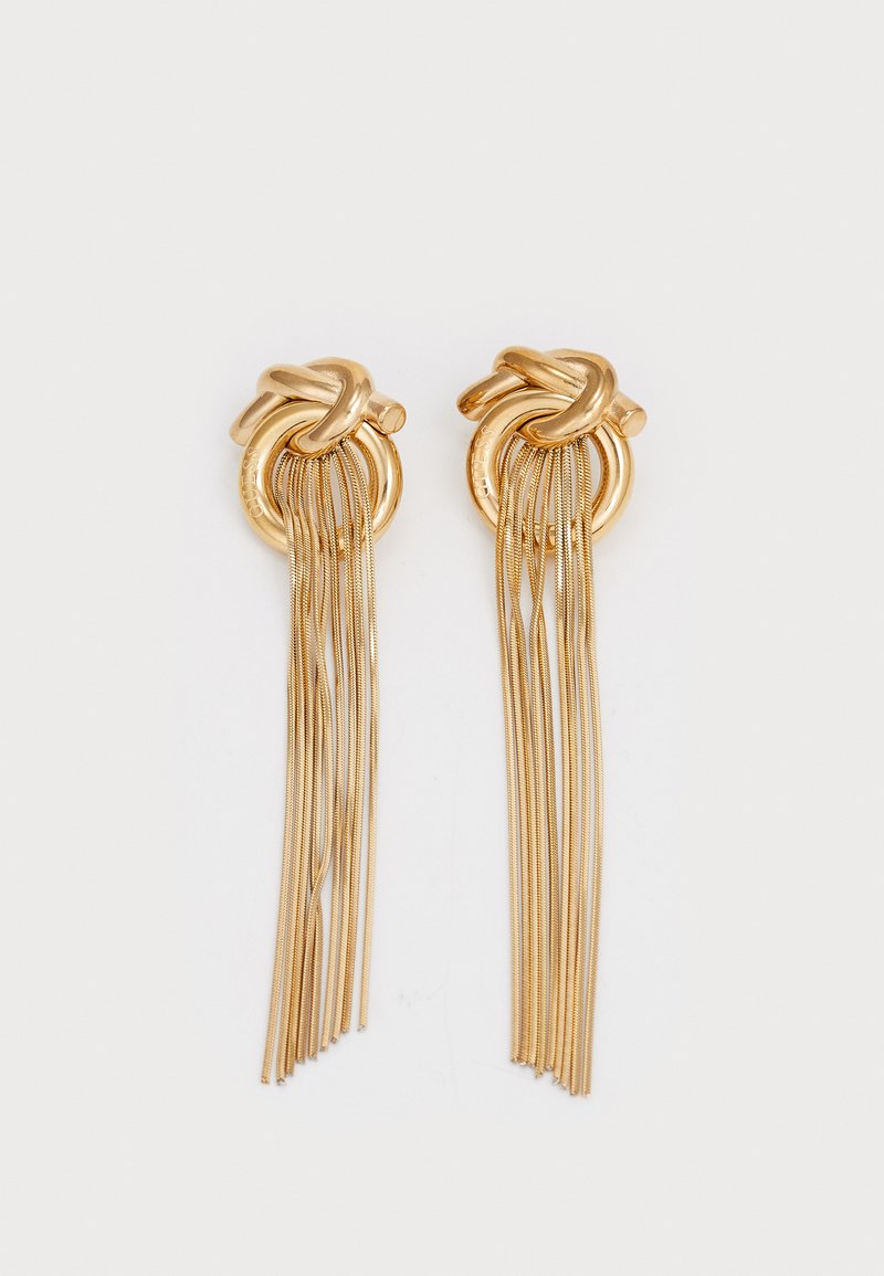 Gold-tone hoop earrings featuring a knot design with long metal fringe. Smooth texture with a shiny finish, creating a bold visual effect.