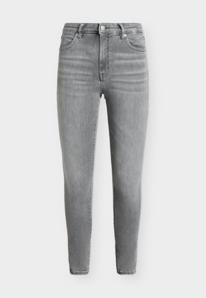 Sivé skinny rifle s vysokým pásom, prednými vreckami, zapínaním na gombíky a jemným vyblednutím na stehnách a kolenách.